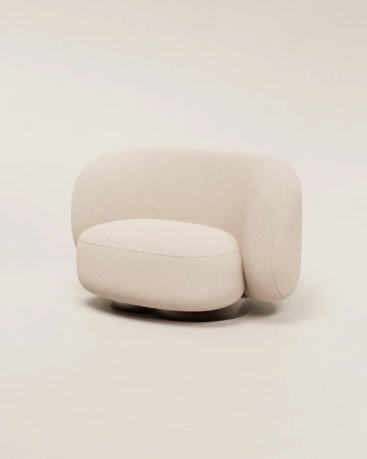 Fauteuil arrondi en tissu bouclette écru, sur fond beige